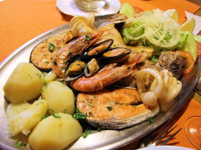 Una fuente de pescado canario a la brasa, marisco y papas arrugadas