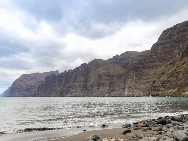 Los acantilados verticales de Los Gigantes sobre una playa de arena negra